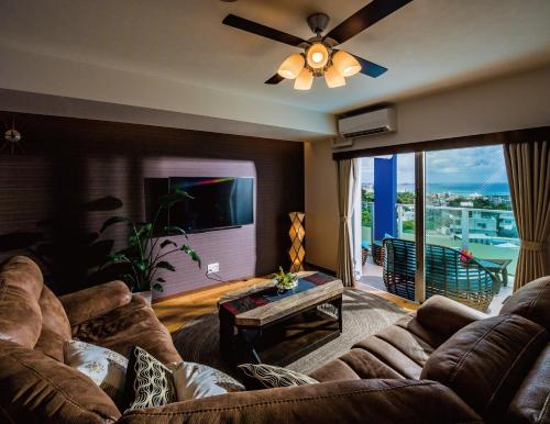 un soggiorno con un divano e un ventilatore a soffitto di Zoe Resort The Sunset Village Okinawa Chatan a Chatan