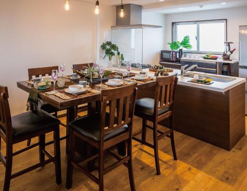 cocina con mesa con sillas y fregadero en Zoe Resort The Sunset Village Okinawa Chatan, en Chatan