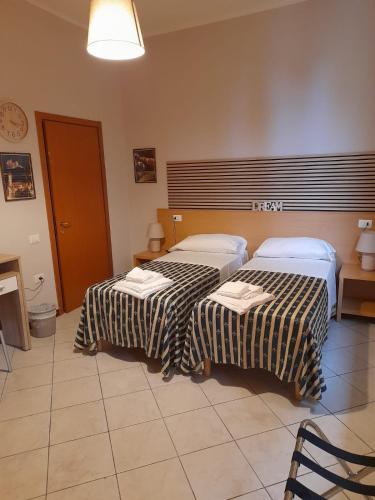 una camera con due letti in una stanza con orologio di vasco rent rooms a Mantova