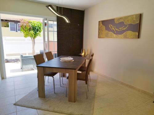 a dining room with a wooden table and chairs at Spacieux Duplex Casa Maya Caleta de Fuste in Caleta De Fuste