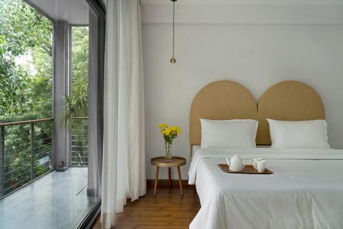 a bedroom with a large bed and a large window at Bungalow 157 in New Delhi