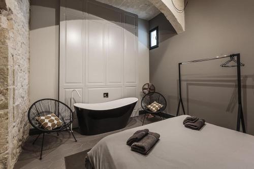 1 dormitorio con cama, bañera y silla en Rabat l.o. MDINA-Designer House THE BEDROOM-TUB, en Rabat