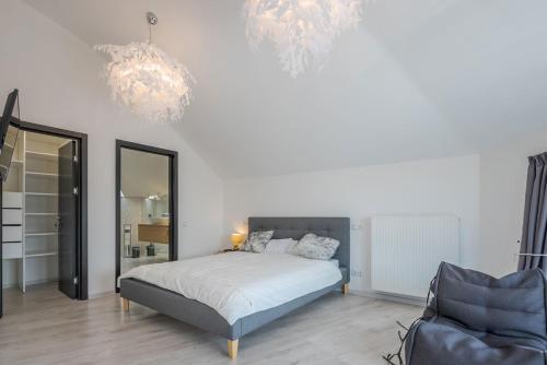 um quarto com uma cama, uma cadeira e lustres em Guest Villa Klaipeda em Klaipėda