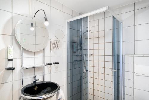 a bathroom with a sink and a mirror at Mainstreet Hotel in Dietzenbach
