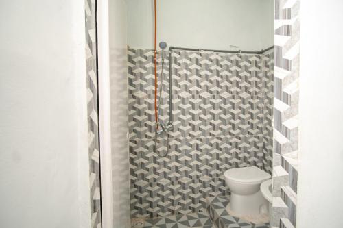 a bathroom with a toilet and a shower at RedDoorz Syariah near Danau Lut Tawar Takengon 2 in Takengon