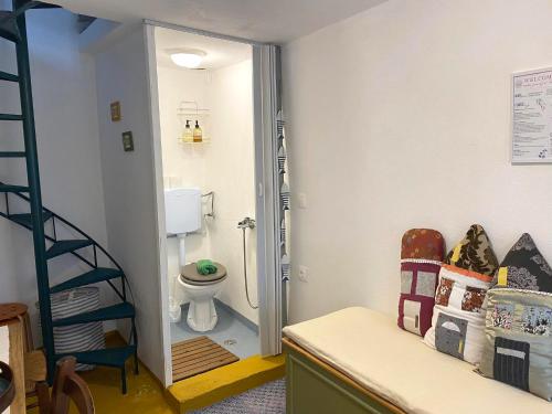 a bathroom with a toilet and a staircase in it at tiny house EFROSSINI in Krásion