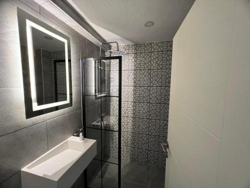 a bathroom with a sink and a mirror at Karaca Suite in Tuzla