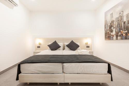 a bedroom with a large bed in a white room at No.48 Apartments in Msida