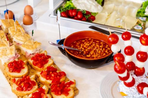 a table topped with sandwiches and a bowl of beans at Hotel Raffaello in Bellaria-Igea Marina
