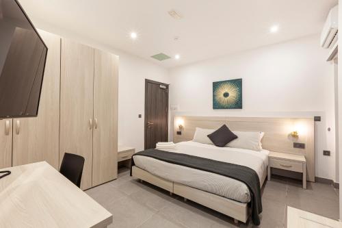a bedroom with a bed and a desk and a tv at No.48 Apartments in Msida
