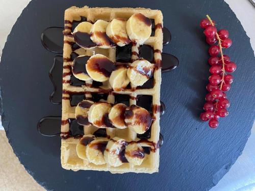 a waffle with fruit and chocolate on a plate at Hôtel La Capitainerie in Châteauneuf-sur-Loire