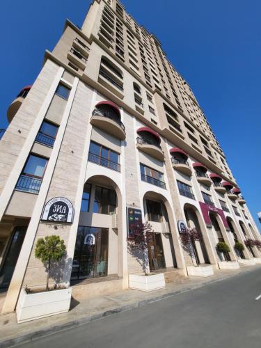 a large white building with windows on a street at Lazuren Bryag Lux suite in Burgas City