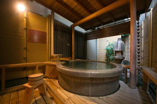 a bath room with a large tub in a room at Furuya Ryokan in Atami
