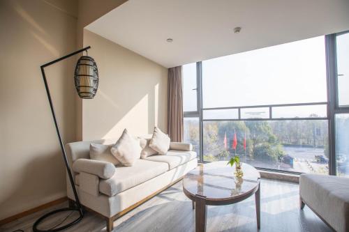 a living room with a couch and a table at Xixi Nanlu Ssaw Boutique Hotel in Hangzhou