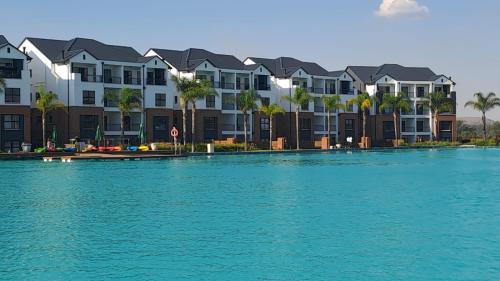 a large body of water with houses and palm trees at Joy Apartment@The Blyde in Pretoria