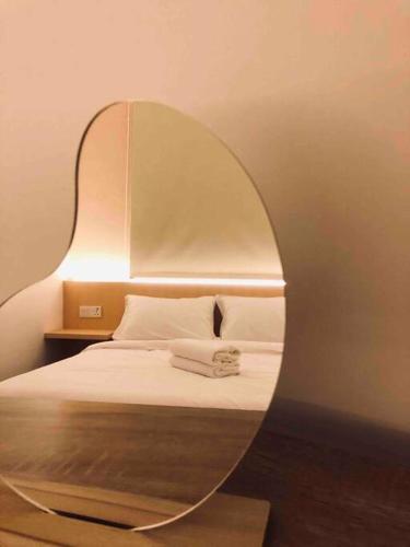 um quarto com um espelho numa cama em ND Minimalistic 2BR Suite Amber Cove Melaka Town em Malaca