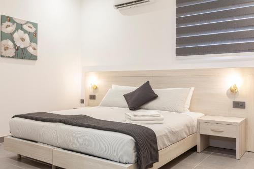 a bedroom with a large bed with white sheets at No.48 Apartments in Msida