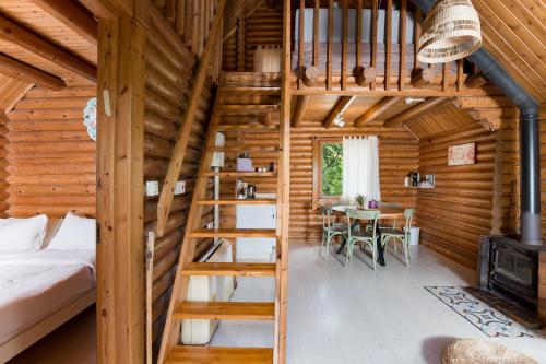 Habitación con cama y escalera en una cabaña de madera en The Scandinavian Village-Teva BaHar en H̱aluẕ