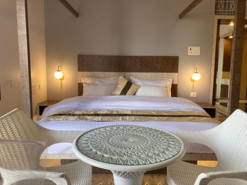 um quarto com uma cama, uma mesa e cadeiras em The Lavish Stay em Varanasi