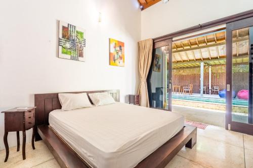 Un pat sau paturi într-o cameră la Surya Villa Manggis