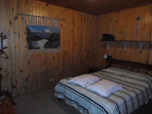 a bedroom with a bed in a wooden wall at Sonja's Almhutte in Campos do Jordão