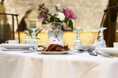 a table with a plate of food on a white table cloth at Les Pierres Lotoises - gîte les grandes pierres in Reilhaguet