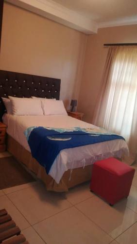sypialnia z dużym łóżkiem i oknem w obiekcie EE Maison Bed and Breakfast w mieście Francistown