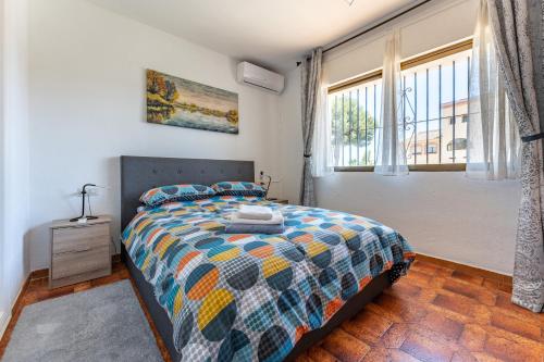 Un dormitorio con una cama y una ventana grande. en Superbly situated villa 67, en Mijas Costa