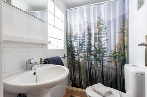 Un baño con lavabo y cortina de ducha. en Superbly situated villa 67, en Mijas Costa