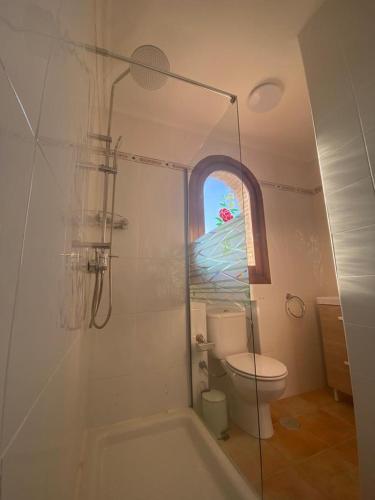 a bathroom with a tub and a toilet and a window at Junto a la playa y vistas al mar in Los Alcázares