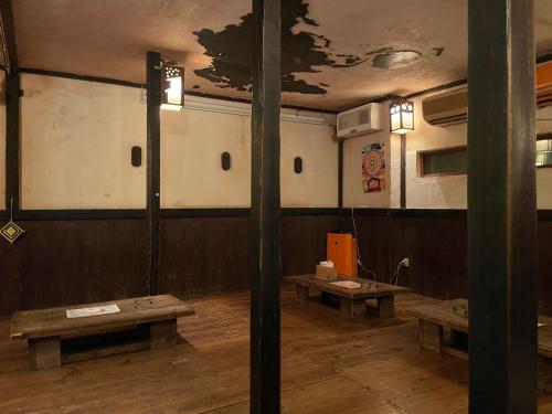 una habitación con bancos y una pared con un mapa. en 月光荘沖縄, en Naha