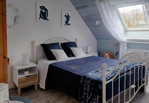 a bedroom with a bed with blue and white sheets at Kerivin in Le Conquet