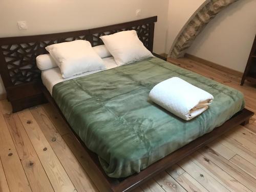 Una cama con dos almohadas encima. en Gîte Le P'tit René, en La Cresse