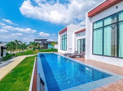 a swimming pool in the backyard of a house at Belong Jin The Dam Resort in Ban Pha Saeng Lang