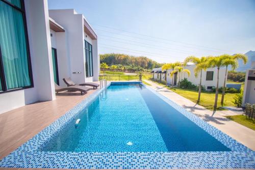 a swimming pool in a villa with a blue tile swimming pool at Belong Jin The Dam Hotel And Resort in Ban Pha Saeng Lang