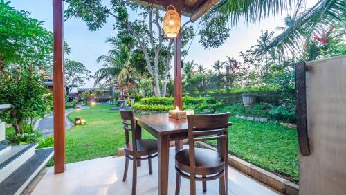 a table and chairs with a view of a garden at Maruan Sari in Ubud