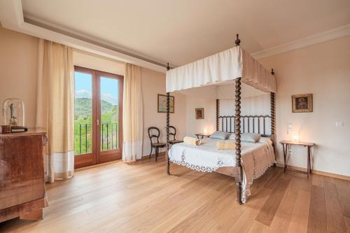 1 dormitorio con cama con dosel y balcón en Ca Nostra de Esporlas, en Esporlas