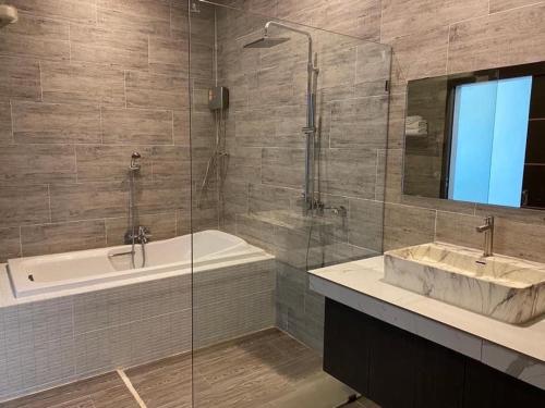 a bathroom with a tub and a sink and a shower at Belong Jin The Dam Hotel And Resort in Ban Pha Saeng Lang