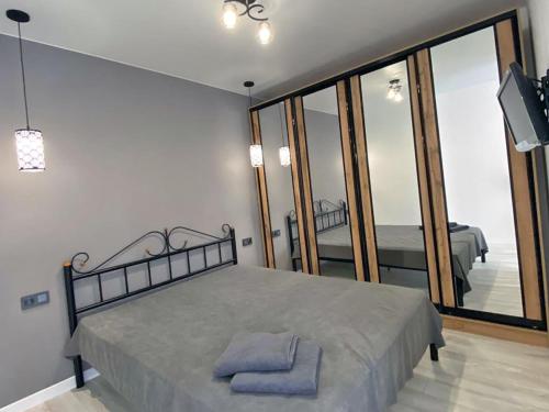 a bedroom with a bed and a large mirror at Пан Апарт #1 in Truskavets