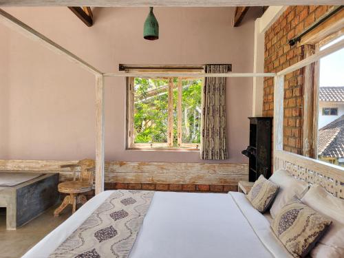 een slaapkamer met een bed en een raam bij Les Rizieres Lombok - Tetebatu in Tetebatu