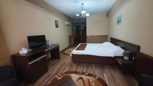 a hotel room with a bed and a television at Guest House Bulevard in Drobeta-Turnu Severin