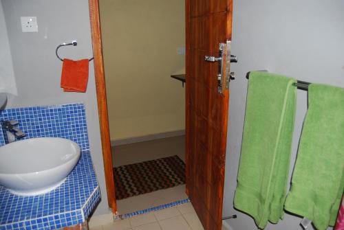 bagno con servizi igienici e asciugamano verde di The Coastal Hotel a Trincomalee