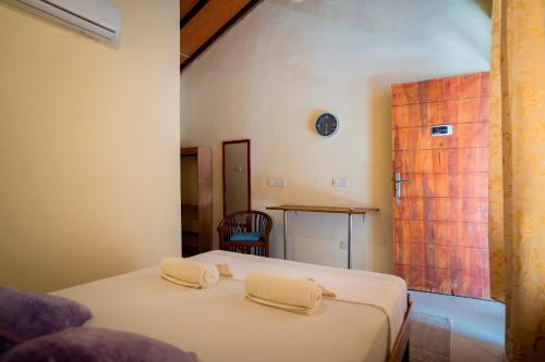 una camera da letto con un letto e due asciugamani di The Coastal Hotel a Trincomalee