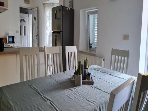 a dining room table with a blue table cloth and white chairs at Holiday Home Mico in Drvenik