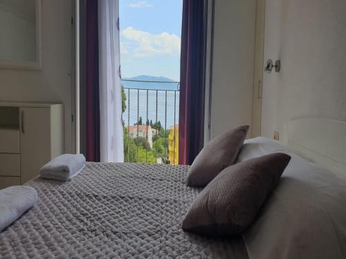 a bedroom with a bed with pillows and a window at Holiday Home Mico in Drvenik