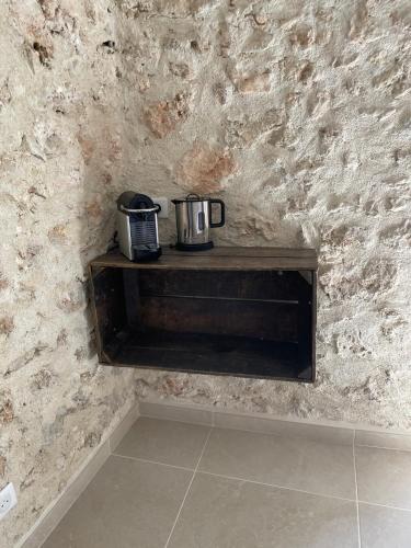 a shelf with two appliances sitting on top of a stone wall at La Parenthèse du Var - Chambre d'hôtes petits déjeuners inclus et terrasse ombragée in Saint Antonin du Var