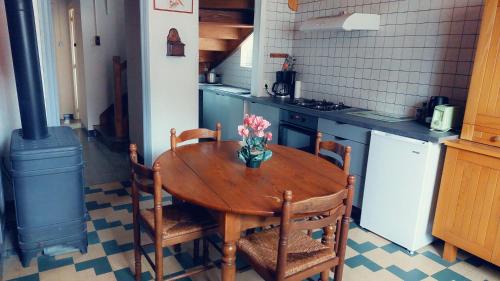 une cuisine avec une table en bois et un vase de fleurs. dans l'établissement Chez Maria, à Charix