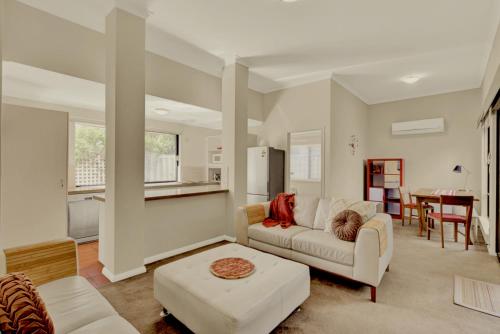 a living room with a couch and a table at Como Executive Apartment in Perth