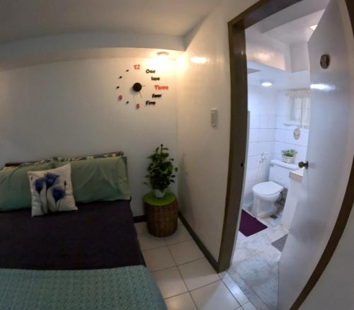 a room with a bed and a bathroom with a toilet at Auntie Gigi's Place in Tagaytay