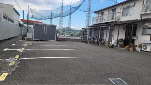 an empty parking lot with bikes parked next to a building at ゲストハウス小富士 in Oita